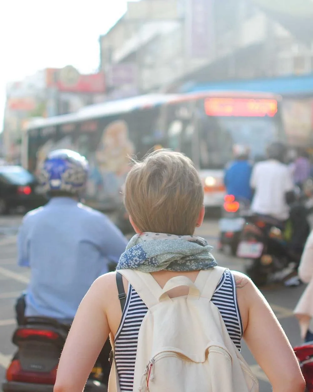 Creator with a backpack walking through a crowded street