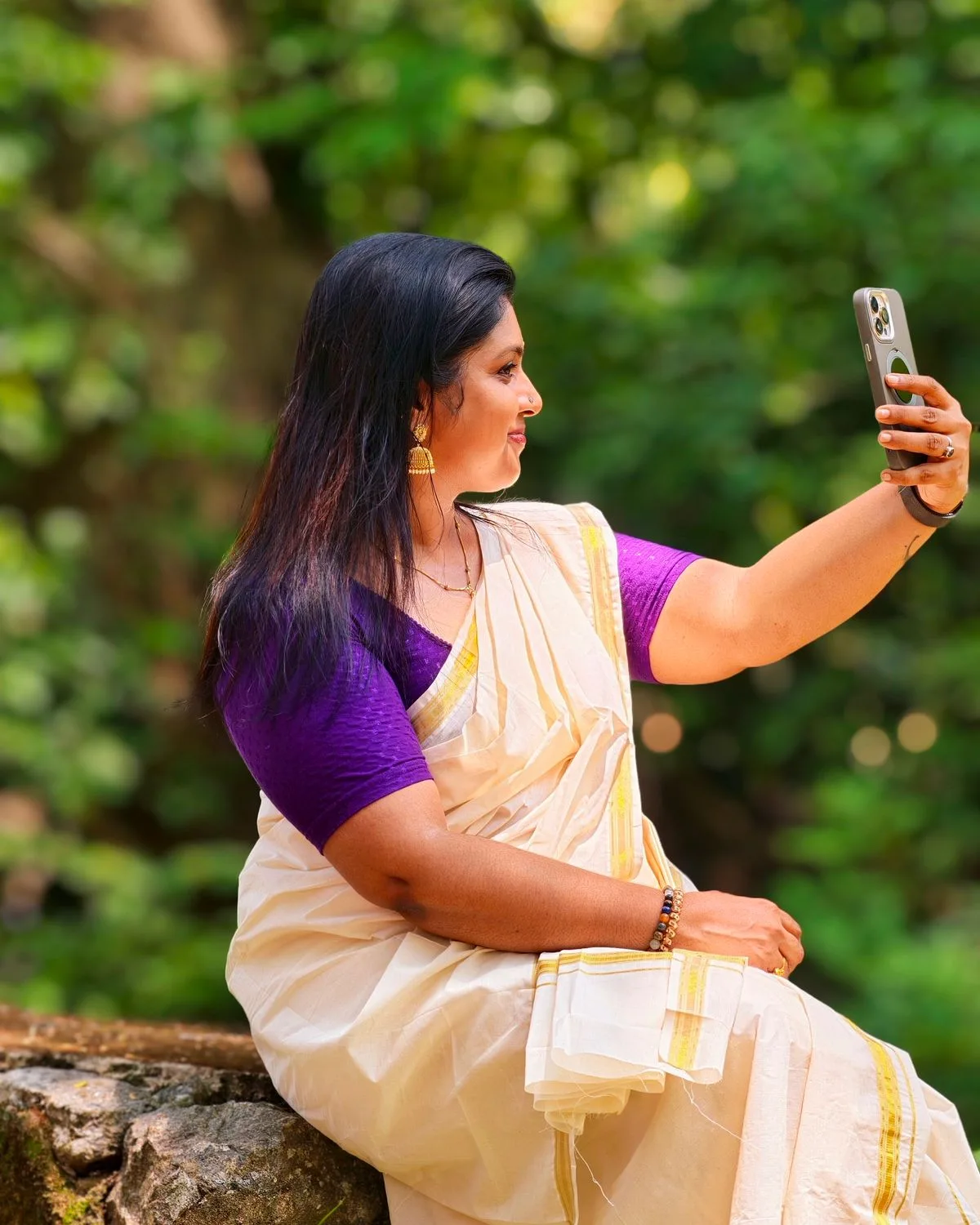 Woman in a Kerala sari taking a selfie outdoors