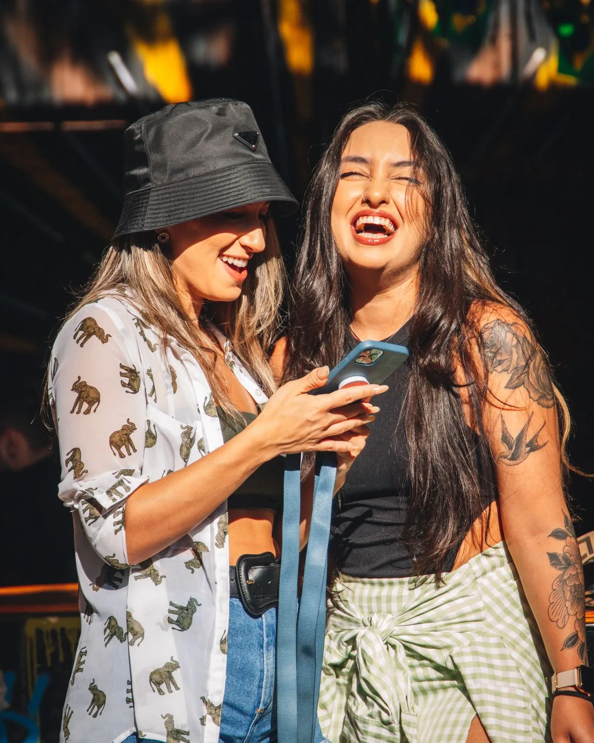 Two friends laughing together over something on a phone