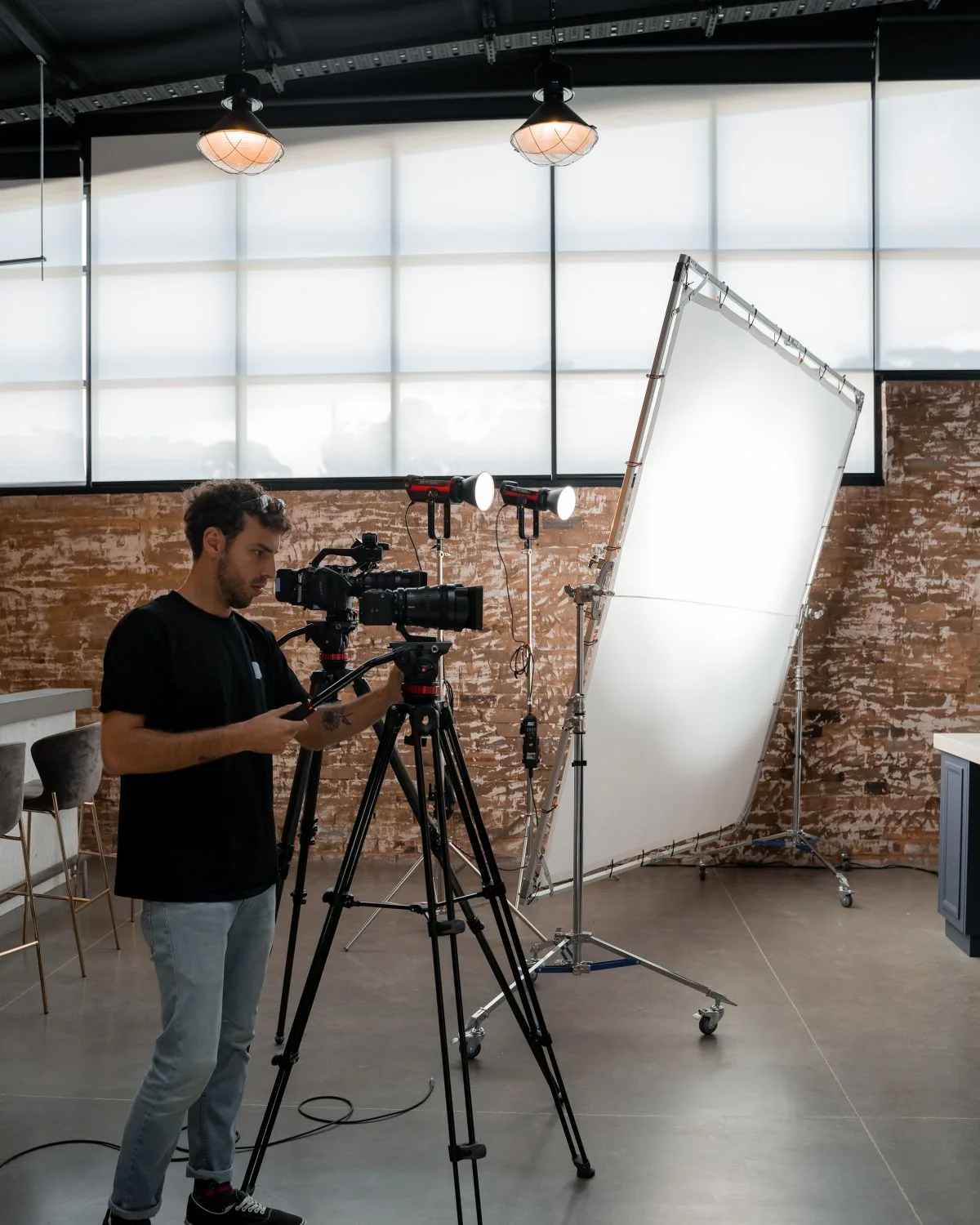 Camera operator setting up a shot in a studio with lights and a diffusion frame